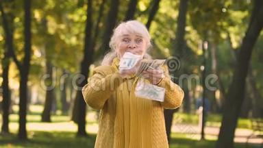 极度幸福的老妇人分散金钱，增加养老金，彩票中奖